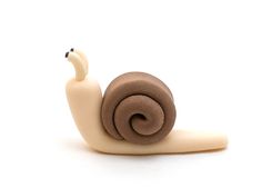 a snail figurine sitting on top of a white surface