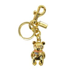 a gold key chain with a teddy bear on it