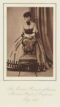 an old black and white photo of a woman sitting on a chair