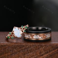 two wedding bands with opal and emeralds on them sitting next to each other