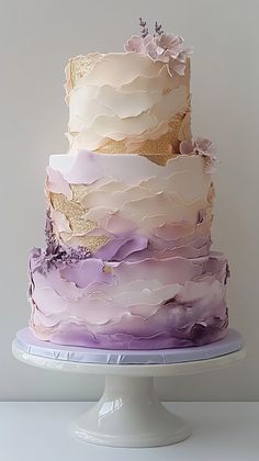 a multi layer cake with purple and white icing