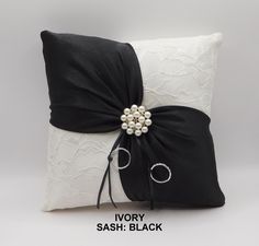 a black and white pillow with a bow on the back that says ivory sash black