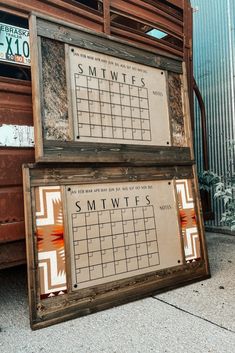 two framed calendars sitting on the side of a building