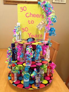 a birthday cake made to look like a tiered stand with bottles and confetti on it