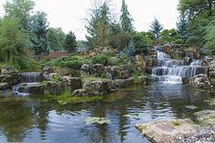 a pond filled with lots of water surrounded by rocks and trees in the middle of it