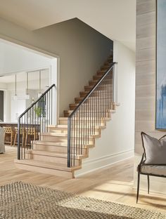 a living room filled with furniture and a stair case next to a painting on the wall