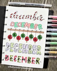 a notebook with the words december written on it and some markers in front of it