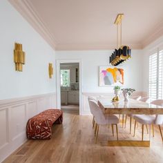 a dining room with white walls and wooden floors