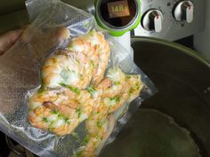 some food is wrapped in plastic and sitting on top of a pot with a thermometer