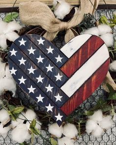 a heart shaped wooden american flag decoration with cotton in the foreground and burlwood wreath behind it