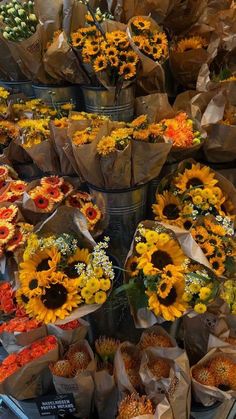 sunflowers and other flowers are on display for sale