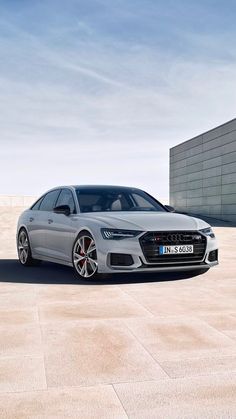 the new audi s8 sedan is parked in front of a building with an empty parking lot