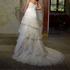 a woman in a wedding dress is standing by a pillar and looking off into the distance