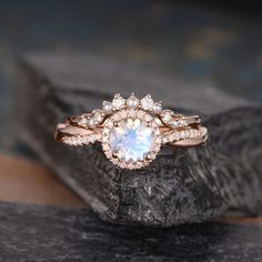 a white diamond ring sitting on top of a rock