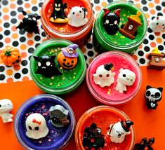 halloween desserts in small plastic containers with sprinkles and decorations on the table