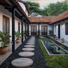 an outdoor courtyard with stepping stones leading to a water feature and potted plants on either side