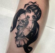 a woman's leg with a black and white tattoo design on her thigh, holding a knife