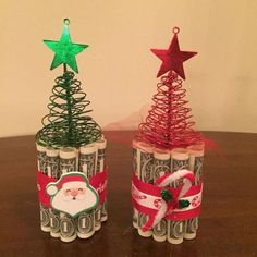 two christmas trees made out of rolled up wrapping paper on top of a wooden table