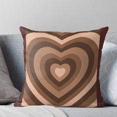 a heart shaped pillow sitting on top of a couch