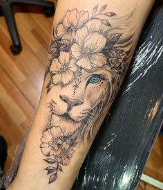 a black and white photo of a lion with flowers on it's head tattoo