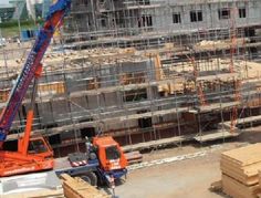 a crane that is standing in the middle of a construction site with lots of scaffolding