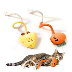 a cat laying on top of a white floor next to three stuffed animals in different shapes and sizes