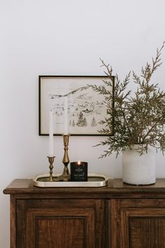 a wooden cabinet with two candles on it