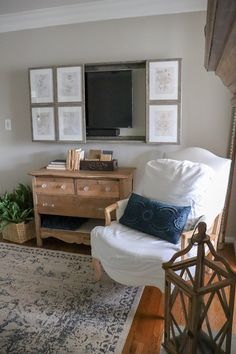 a living room with a white chair and television