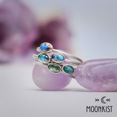 This dainty Silver Oval Labradorite Stacking Ring Set features a 6 x 4 mm oval cabochons, shown here in Labradorite. The bands have a smooth round wire band, shown here with a matte finish. These rings fit together as a stacking ring set and look great. Due to the nature of labradorite, individual pieces vary in color, but the stones we use all have sheen, color play, and depth. Sterling Silver Stacking Rings, 6 x 4 mm Cabochon Stones Dimensions: - Each Band: 1 mm (approx. 0.01 in), From Finger Sterling Silver Stacking Rings, Stacking Ring Set, Color Play, Silver Stacking Rings, Ring Fit, Stacking Ring, Stacking Rings, Free Jewelry, Ring Set