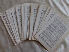 six old sheet music manuscripts laid out on a bed