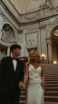 a man and woman are walking down the stairs