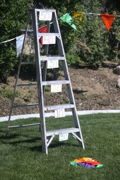 a ladder that has been placed on the grass with some cards attached to it,