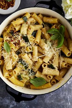 pasta with spinach and parmesan cheese in a white pot on a table