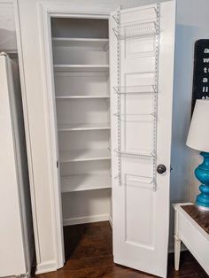 an open closet with shelves and lamps in the corner, next to a lamp on a table