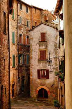 an alley way with old buildings and green shutters