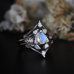 "This set of 3 rings features a Moonstone engagement ring with two diamond V bands. A pretty 7x5 mm pear cut rainbow moonstone, with accent diamonds forming a trillion, sitting on a split shank with diamond kites - this unique engagement ring is a perfect choice for your enigmatic other half, her mystic side which you just cannot fathom! Stack it with our versatile 3 pear diamond V rings to complete the look. These rings are crafted in solid 14k or 18k gold with natural diamonds and gemstones. * V Rings, V Ring, Moonstone Engagement, Moonstone Engagement Ring, Wedding Engagement Ring, Natural Rainbow, Engagement Ring Set, Split Shank, Pear Diamond