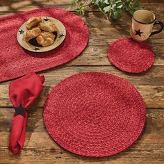 red placemats and coasters on wooden table with coffee cup, plant and plate