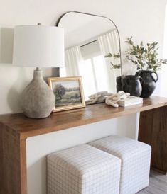 a table with two stools and a mirror on it