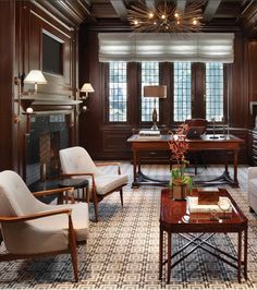 a living room filled with lots of furniture and wooden paneled walls, along with a fire place