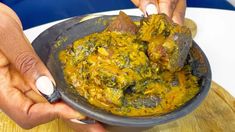 two hands holding a bowl filled with food