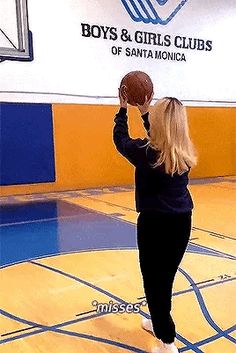 a woman holding a basketball up to her face