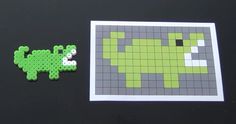 an image of a pixel art piece next to a sticker with a green lizard on it