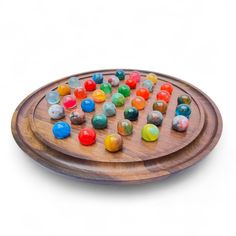 a wooden platter filled with lots of colorful candies on top of each other