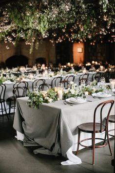 tables with white linens and greenery are set up for an elegant wedding reception