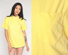 "Vintage 90s t shirt in yellow cotton with a pocket on the chest. Please see measurements and condition below. Every garment we sell is authentic vintage and one-of-a-kind! You will receive the exact item photographed. Condition: Has a pinhole near the waist. See photos Best fits women's: Labelled Medium Tag: B.V.D Material:  Cotton MEASUREMENTS Taken from seam to seam while the garment is lying flat. Double the armpit, waist, and hips For reference, model is 5'6\" and measures 32-26-37.  Length Pink Babydoll Dress, Calico Dress, Plaid Jumper, Dolly Dress, Apron Dress, T Shirt Costumes, Prairie Dress, Chiffon Long Sleeve, Basic Shirts