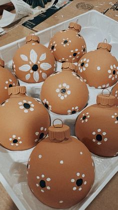 there are many brown ornaments in the box on the table and one is decorated with white flowers