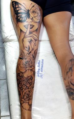 a woman's leg with tattoos on it and flowers in the bottom right corner