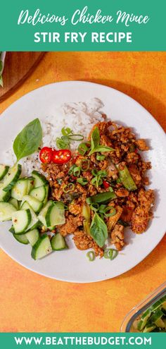 a white plate topped with meat and veggies next to rice on top of a table