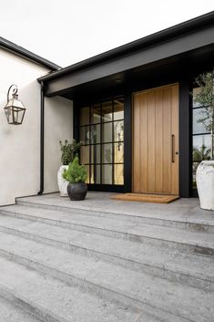 the entrance to a house with steps and potted plants