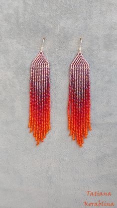 two pairs of orange and red beaded earrings on a gray surface with the words, ta